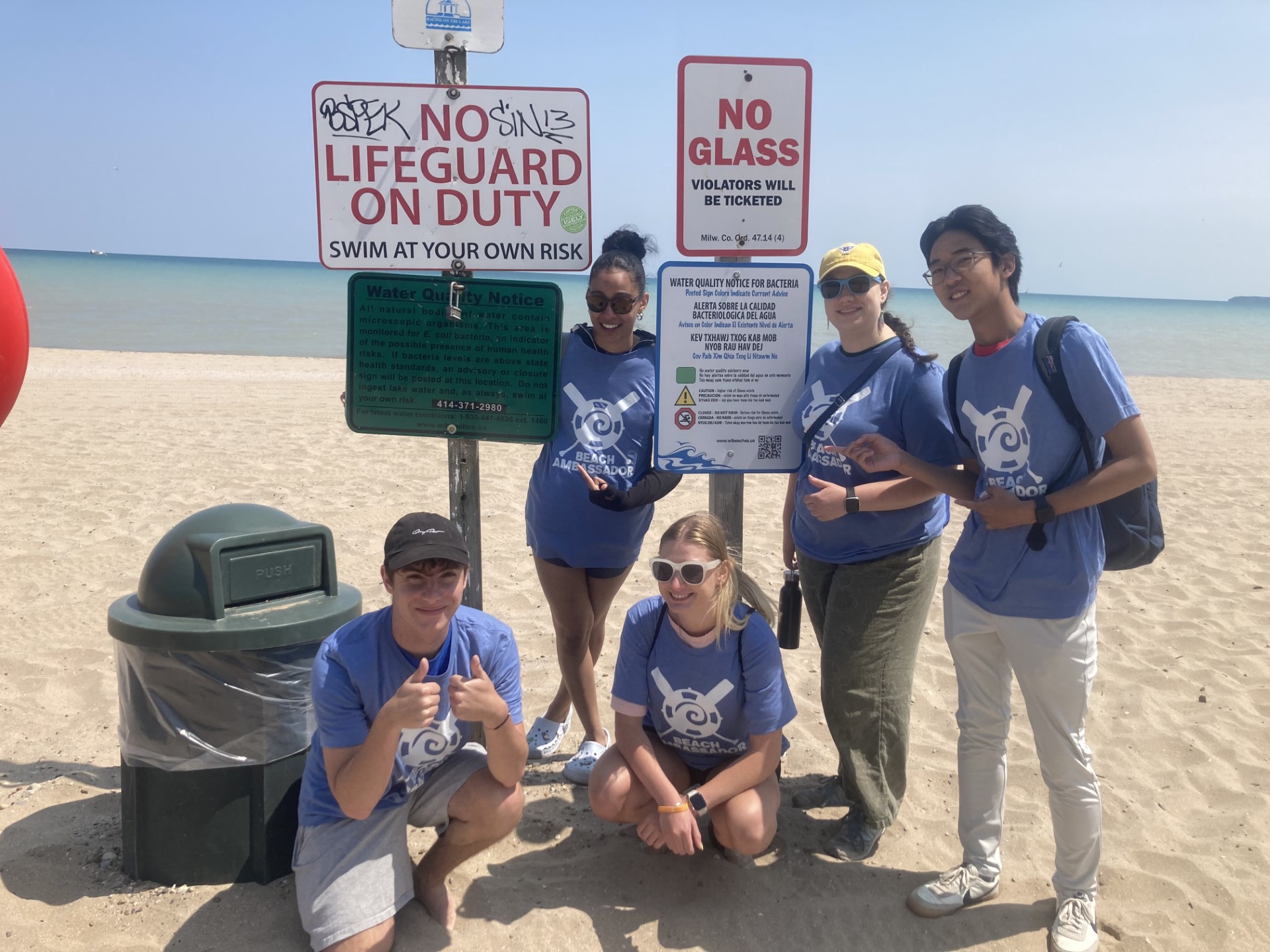 Beach Amabssadors stand in front of water quality sign